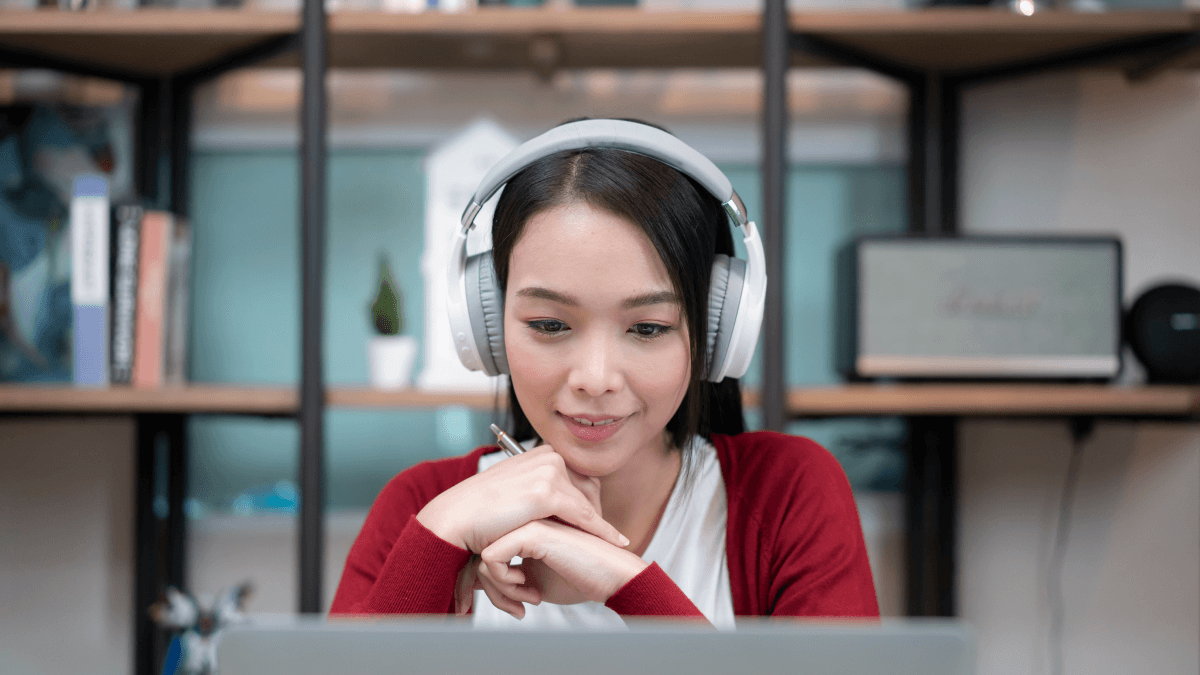 woman wearing big headphones taking online language classes